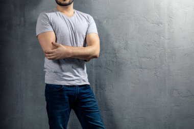 Sağlıklı genç boşaltmak metniniz için beton zemin üzerine gri T-shirt ile. Modeli yüz resim.