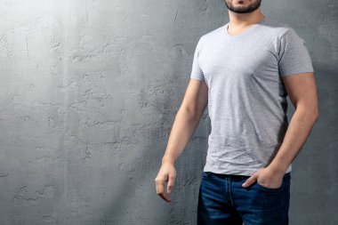 Sağlıklı genç boşaltmak metniniz için beton zemin üzerine gri T-shirt ile. Modeli yüz resim.