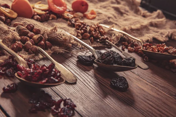 Fruits secs et noix disposés sur une cuillère, un tissu et une vieille table — Photo