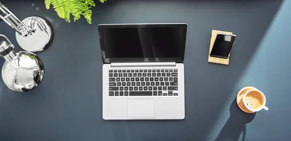 Laptop mit Kaffee und Smartphone auf dem Schreibtisch. — Stockfoto