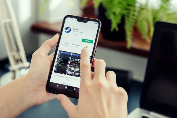 WROCLAW, POLAND - JULY 31th, 2019: Woman installs Netflix application on the Xiaomi A2 smartphone. — Stock Photo, Image