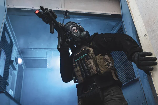 Soldado de la unidad especial con máscara de gas está saliendo de industrial —  Fotos de Stock