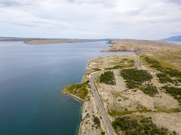 Aerial view of the coast of Croatia, winding roads and coves with crystal clear sea. Coast of the island of Pag