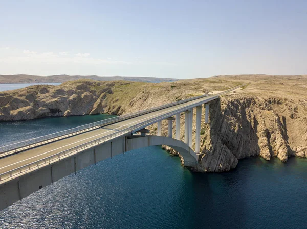 Aerial view of the bridge of the island of Pag, Croatia, roads and Croatian coast. Cliff overlooking the sea. Cars crossing the bridge seen from above