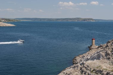 Hırvatistan, 29/06/2018: güneşli gün ve Paski çoğu, ana toprak ve Pag Island bağlanır 1968 köprü önünde uçurumdaki görünümü küçük kırmızı fener ve bir sürat teknesi