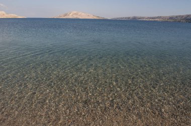 Hırvatistan, 30/06/2018: Rucica, köy Metajna, ünlü Pag Island üzerinde çöl manzara güneydoğusunda çevrili çorak bir koyda yer alan çakıllı plaja kristal berraklığında su