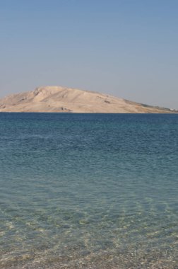 Hırvatistan, 30/06/2018: Rucica, köy Metajna, ünlü Pag Island üzerinde çöl manzara güneydoğusunda çevrili çorak bir koyda yer alan çakıllı plaja kristal berraklığında su