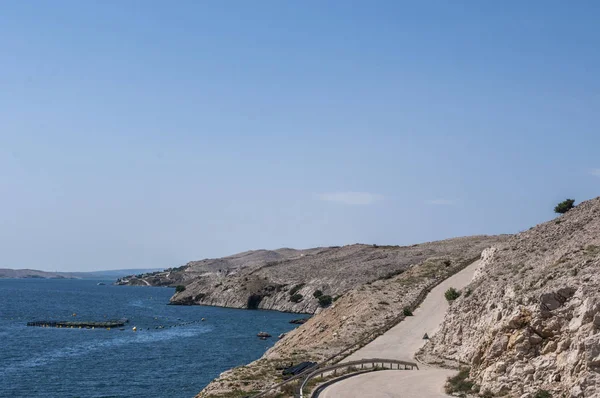 Croatia, 30/06/2018: a winding road down to the beach on the island of Pag, the fifth-largest island of the Croatian coast in the northern Adriatic Sea and the one with the longest coastline