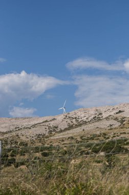 Hırvatistan, 30/06/2018: Akdeniz maki ve Hırvat en büyük beşinci Island Pag Island yolda Marnixkade bir rüzgar türbini sahil Kuzey Adriyatik Denizi 