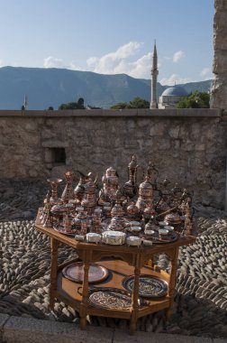 Bosna-Hersek, 5/07/2018: tipik bakır çay ve kahve ile küçük bir tablo ayarlar Satılık ve Mostar Koski Mehmed Paşa Camii ile manzarası görünümünü arka planda