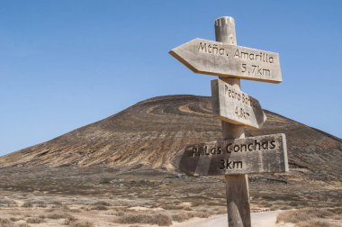 Lanzarote, Kanarya Adaları, 12/09/2018: Montana Pedro Barba, ikiz-summitted ve ikiz krateri volkan La Graciosa, ana adalar ada Chinijo ve ana adanın turistik yerlere ahşap işaretler