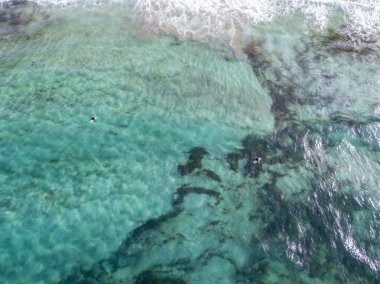 Dalgalar ve sörfçü ile berrak bir deniz hava görünümü. Playa De La Canteria. Atlantik Okyanusu, dalgalar kumsalda gün batımında, çökmesini arka aydınlatma. Orzola, Lanzarote, Kanarya Adaları. İspanya