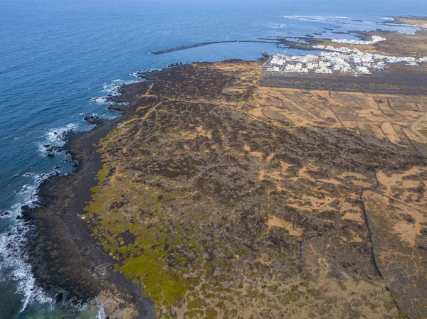 Aerial view of the country of Orzola and the indented coastline of the island of Lanzarote, Canary Islands, Spain. Africa. Reliefs overlooking the sea and dirt paths. Hiking trails