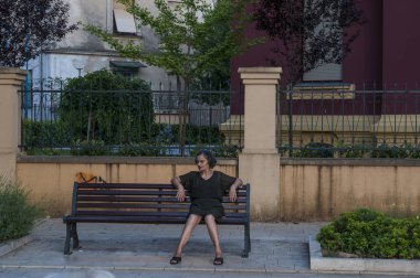 Bosna, 07/07/2018: Bosnalı kadın giyinmiş siyah ve makyaj oturma bir banka Zrinjski City Park, Mostar Şehir Batı tarafındaki genel bir park