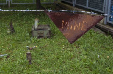 Sarajevo, 08/07/2018: barbed wire and warning sign for landmines in the reproduction of a minefield at the Sarajevo Tunnel Museum which housing the underground tunnel built in 1993 during the Siege of Sarajevo clipart