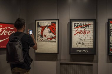 Galerija Müzesi, Saraybosna, 08/07/2018: Saraybosna remake ünlü reklam veya sanat kuşatma hakkında uyarmaya gelen serisi oluşturan grafik tasarım grup Trio Saraybosna eserlerini izleyen bir adamım, saygılar