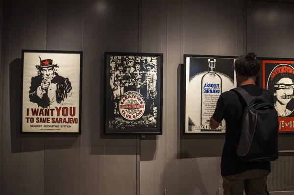 Galerija 博物館 サラエボ 2018 トリオ サラエボの作品を見ている男 シリーズを作成したグラフィック デザイン グループの有名な広告や作品の包囲について警告するサラエボのリメイクからよろしく — ストック写真