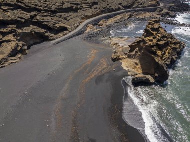Bir kaya oluşumu üzerinde çökmesini dalgalar hava görünümünü. Playa El Golfo. Siyah beach Charco de Los Clicos. Lanzarote, Kanarya Adaları, İspanya