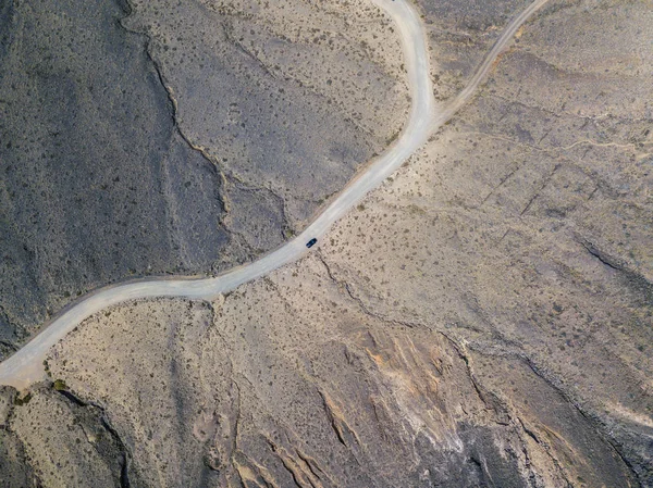 Aerial view of a car in the desert valleys of the island of Lanzarote, Canary Islands, Spain. Paths and roads