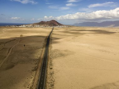 Üzerinde Adası Lanzarote, Kanarya Adaları, İspanya'nın havadan görünümü ıssız bir manzara. Bir çöl geçen yol. Dil siyah asfalt bir çöl kara kesme. Kabartmaları ufukta. Volkanlar.