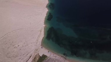 Hırvatistan 'ın Metajna kentindeki Pag Adası' ndaki Rucica plajının hava manzarası. Deniz yatağı ve plaj yukarıdan görünüyor, banyolar, rahatlama ve yaz tatilleri. Hırvat kıyılarının önyargıları ve uçurumları