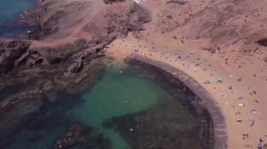 Lanzarote, İspanya ve Kanarya 'nın sivri kıyılarının havadan görünüşü. Yollar ve toprak yollar. Adayı keşfetmek için yürüyüş rotaları. Kumsalda yüzüyor. Atlantik Okyanusu. Papagayo