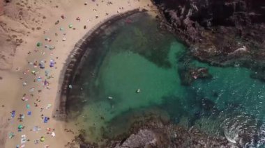 Lanzarote, İspanya ve Kanarya 'nın sivri kıyılarının havadan görünüşü. Yollar ve toprak yollar. Adayı keşfetmek için yürüyüş rotaları. Kumsalda yüzüyor. Atlantik Okyanusu. Papagayo