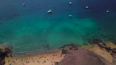 Lanzarote, İspanya ve Kanarya 'nın sivri kıyılarının havadan görünüşü. Yollar ve toprak yollar. Adayı keşfetmek için yürüyüş rotaları. Kumsalda yüzüyor. Atlantik Okyanusu. Papagayo