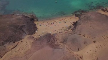 Lanzarote, İspanya ve Kanarya 'nın sivri kıyılarının havadan görünüşü. Yollar ve toprak yollar. Adayı keşfetmek için yürüyüş rotaları. Kumsalda yüzüyor. Atlantik Okyanusu. Papagayo