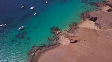 Lanzarote, İspanya ve Kanarya 'nın sivri kıyılarının havadan görünüşü. Yollar ve toprak yollar. Adayı keşfetmek için yürüyüş rotaları. Kumsalda yüzüyor. Atlantik Okyanusu. Papagayo
