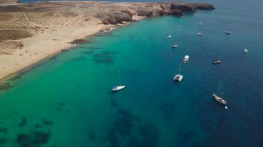 Lanzarote, İspanya ve Kanarya 'nın sivri kıyılarının havadan görünüşü. Yollar ve toprak yollar. Adayı keşfetmek için yürüyüş rotaları. Kumsalda yüzüyor. Atlantik Okyanusu. Papagayo