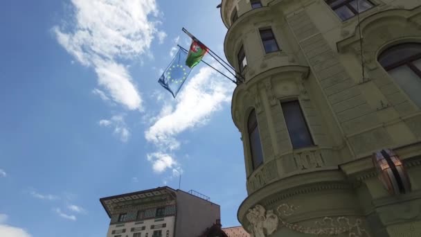 スロベニア最大の都市と首都リュブリャナ市内中心街は 2018 市内の歩行者エリアに散歩の人達 教会と丘の上の城 スロベニア国旗 — ストック動画