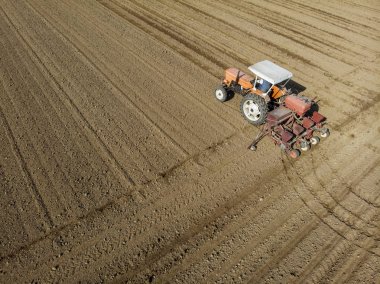 Aerial view of a tractor plowing the fields, aerial view, plowing, sowing, harvest. Agriculture and Farming, campaign. Desert and dehydrated lands, global warming clipart