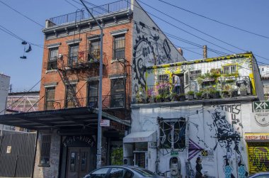 New York City Williamsburg mahallede 6 St tipik Brooklyn binası, ABD. 09/19/2014. Terasta bisiklet ayarlayan adam