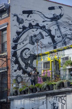 New York City Williamsburg mahallede 6 St tipik Brooklyn binası, ABD. 09/19/2014. Terasta bisiklet ayarlayan adam