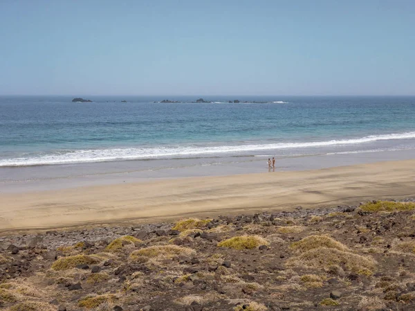 Ludzie Spacerują Wybrzeżu Famara Plaży Górach Widokiem Ocean Lanzarote Wyspy — Zdjęcie stockowe