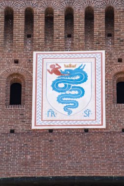 Milan, Italy, Europe, 03/28/2019: view of the biscione, an azure serpent in the act of consuming a human, the emblem of the House of Visconti and of the city from the 11th century, on the Filarete Tower of the Sforza Castle (Castello Sforzesco) clipart
