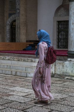 Saraybosna, Bosna-Hersek, 07/ 08/ 2018: Bosna- Hersek' in Bascarsija semtindeki en büyük tarihi cami olan Gazi Hüsrev Dilenci Camii' nin (1532) avlusinda yürüyen, peçeli bir kız