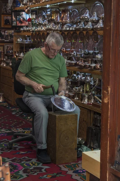 萨拉热窝 波斯尼亚和黑塞哥维那 2018 一名铜匠在巴斯卡西亚市中心的铜匠街车间内工作 该城市是旧集市和历史文化中心 — 图库照片