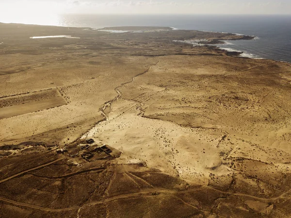 Aerial view of a desert landscape on the island of Lanzarote, Canary Islands, Spain. Desert background, texture. Sand and desolate land