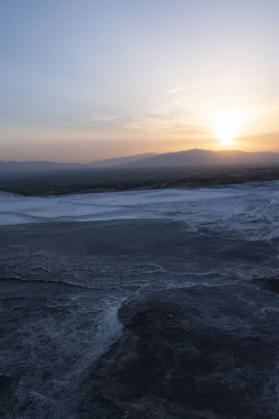 Türkiye, Pamukkale 'de Traverten teraslarında gün batımı (Cotton Castle), su tarafından akan suda kalan bir karbonat minerali ile ünlü kaplıcalardan su yatırılan tortul kayanın doğal alanı