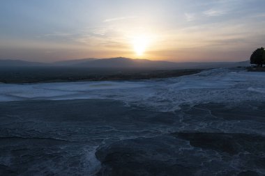 Türkiye, Pamukkale 'de Traverten teraslarında gün batımı (Cotton Castle), su tarafından akan suda kalan bir karbonat minerali ile ünlü kaplıcalardan su yatırılan tortul kayanın doğal alanı