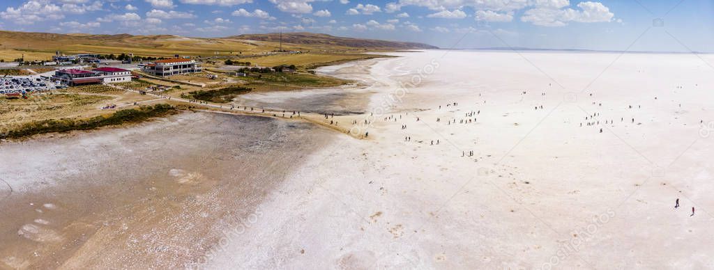 Aerial view of Lake Tuz, Tuz Golu. Salt Lake. White salt water. It is the second largest lake in Turkey and one of the largest hypersaline lakes in the world. Anatolia Region, Ankara, Aksaray, Konya. People standing in the middle of the lake