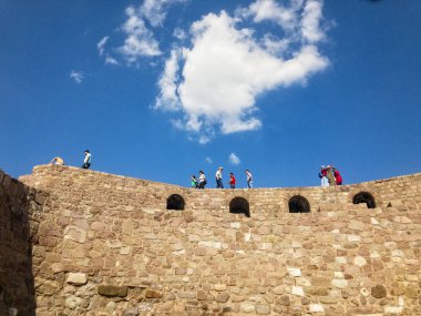 Ankara Kalesi'nin (Kale) duvarlarının panoramik manzarası, duvarlarda yürüyen insanlar. Bulutlarla güneşli bir gün. 06/27/2019. Türkiye'nin başkenti. Tarihi eser