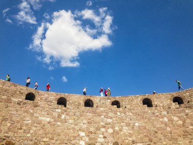Ankara Kalesi'nin (Kale) duvarlarının panoramik manzarası, duvarlarda yürüyen insanlar. Bulutlarla güneşli bir gün. 06/27/2019. Türkiye'nin başkenti. Tarihi eser