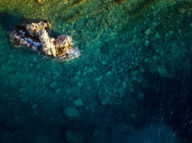 Denizden çıkan kayalarla deniz tabanının havadan görünümü, yukarıdan görülen deniz dibi, şeffaf su
