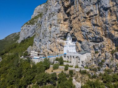 Ostrog Manastırı'nın havadan görünümü, Karadağ'daki Ostroka Greda'nın büyük kayasının yükseklerinde, neredeyse dikey bir arka plan üzerinde yer alan Sırp Ortodoks Kilisesi. Ostrog'un Aziz Basil'ine ithaf edimi. Dolambaçlı yollar