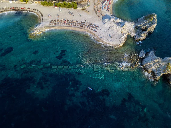 黑山布德瓦岛Sveti Nikola的空中景观 夏威夷海滩 遮阳伞和浴池 水晶清澈的海水 锯齿状的海岸 陡峭的悬崖俯瞰着透明的大海 野生生物和地中海生物 — 图库照片