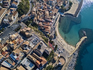 Pizzo Calabro, rıhtım, kale, Calabria, İtalya turizmi. Deniz kenarındaki küçük Pizzo Calabro kasabasının panoramik manzarası. Kayalıklardaki evler. Uçurumun kenarında Aragon kalesi duruyor. Deniz önü 