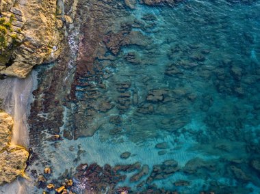 Denizde kayaların havadan görünüşü. Yukarıdan görünen deniz tabanının genel görünümü, şeffaf su. Deniz yatağı. Pizzo Calabro, Calabria, İtalya